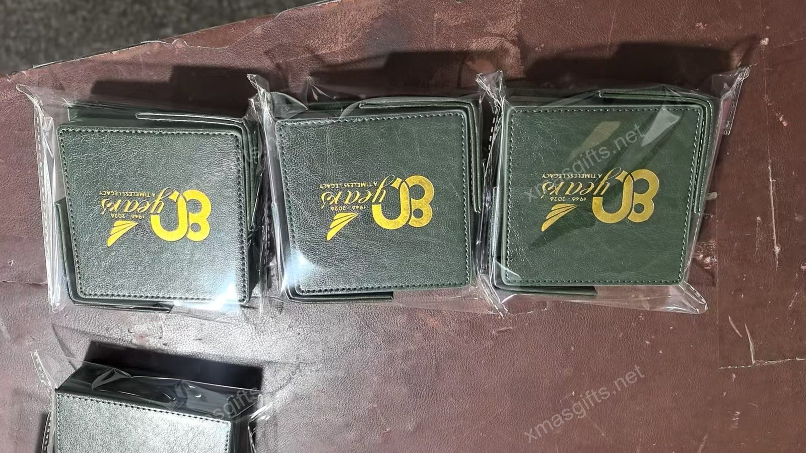 Green leatherette coaster with gold foil 80th anniversary logo